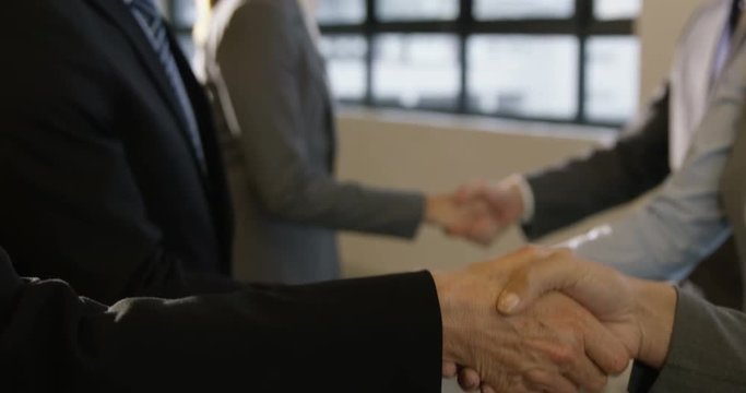 Business people having a handshake in hallway