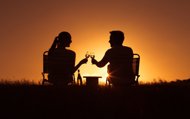 Fototapeta na wymiar Couple relaxing in the park enjoying a glass of wine. 