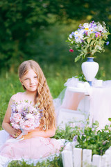 Happy little girl playing with bouquet in sunny park