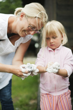 Sweden, Gotland, Faro, Mother and daughter (4-5) moulding clay