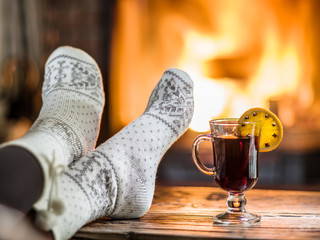 Warming and relaxing near fireplace with a cup of hot wine.
