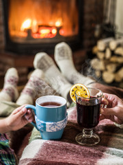 Warming and relaxing near fireplace with a cup of hot drink. © volff