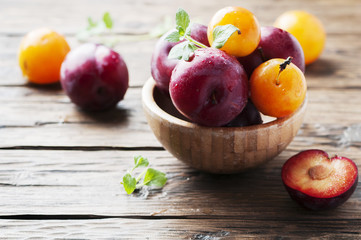 Sweet fresh black and yellow plums on the table