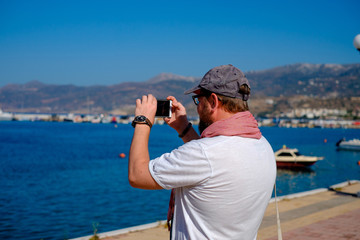 Obraz premium Young man doing selfie on the beach