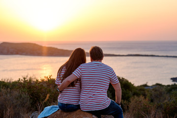 Romantic of couple love sitting on the stone looking sunset at mountain