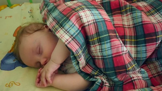 Slow motion shot of a baby boy sleeping in crib at home in bedroom