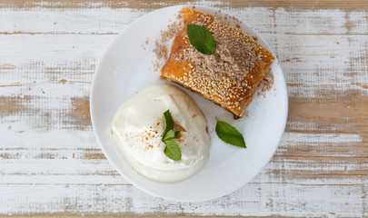 Piece of traditional apple strudel pie served with ice-cream, fresh mint, raspberry and glass of wine