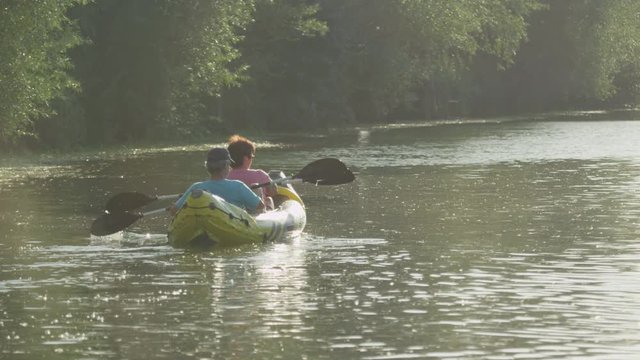 SLOW MOTION: Couple kayaking along the beautiful river in summer