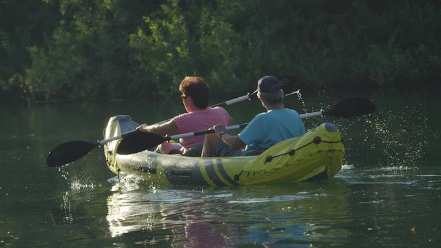 SLOW MOTION: Mature Couple Canoeing On Beautiful Calm River