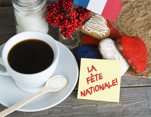 The National Celebration In France La fete nationale (Bastille Day) - text, Heart shaped cookies color red, blue, white. Cup of coffee (tea), france flag, decoration. Patriotic Breakfast Concept.