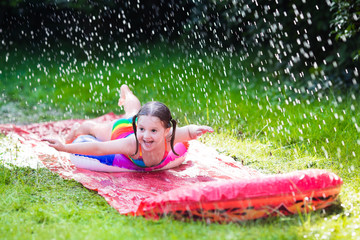 Child playing with garden water slide
