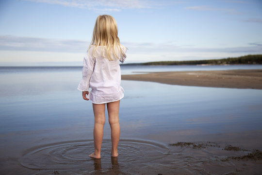 Rear view of girl standing in sea