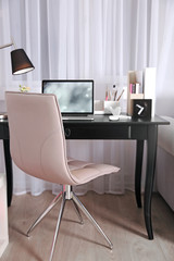 Workplace with laptop on table at home