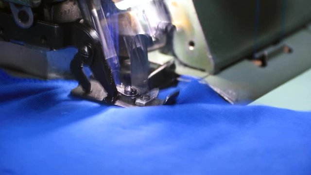 Professional overlock sewing machine with blue fabric