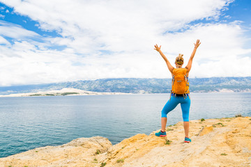 Woman hiker with arms outstretched, travel celebrating