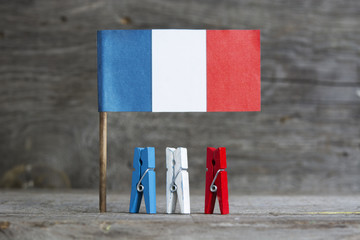 wooden clothespins red, white, blue color against the backdrop of the French flag. Patriotic...