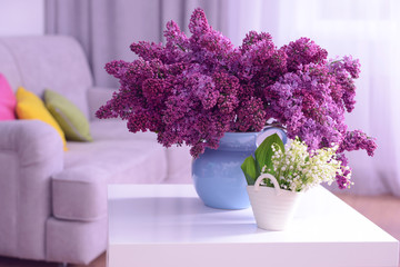 Lilac and may-lily flowers on white table