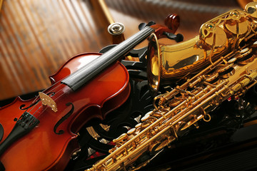 Violin and saxophone lying on piano, close up