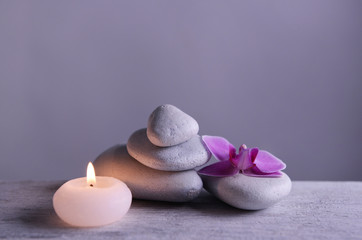 Obraz na płótnie Canvas White spa stones with candle on gray background