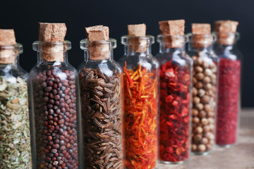 Different spices in small glass bottles, close-up