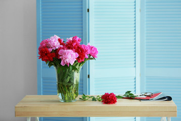 Fototapeta na wymiar Fresh peony bouquet on folding screen background