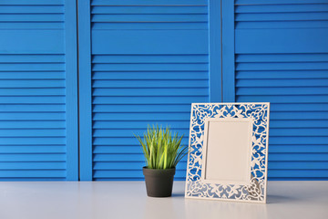 Photo frame with green plant on blue folding screen background