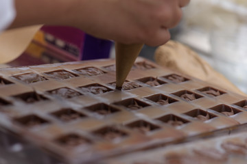 Pouring chocolate into metal molds