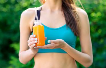 Sportswoman drinking detox juice on street