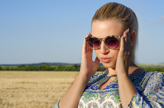 Fashionable sensual blonde emphasizing sunglasses 