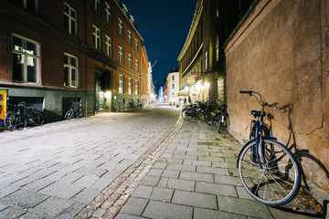 Bicycle parked along a narrow street at night, in Copenhagen, De