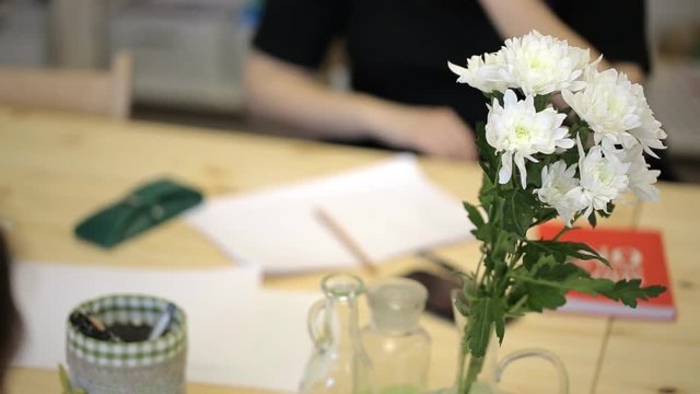 Office workers came to caucus and sat at table with flowers.