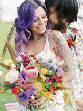 Sweden, Groom kissing bride at hippie wedding