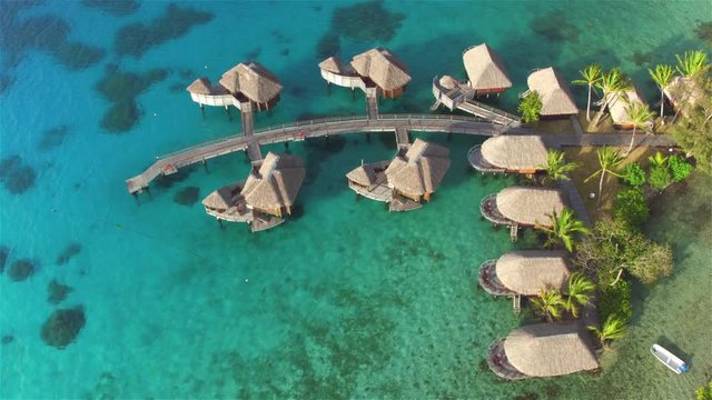 AERIAL: Large luxurious overwater villas above the water in resort