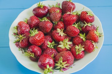 Fresh strawberry on the plate  blue background