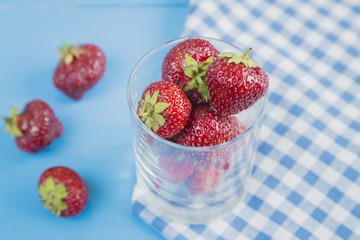 Glass of red strawberry with some berries
