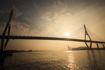 Fototapeta na wymiar silhouette photo of sun rising sky at bhumiphol bridge important transport and moder