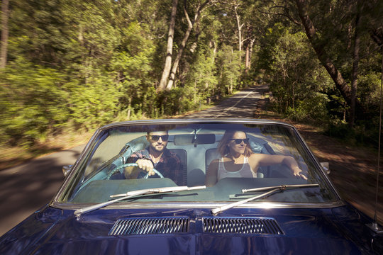 Australia, New South Wales, Sydney, Lane Cove, Couple driving car through forest
