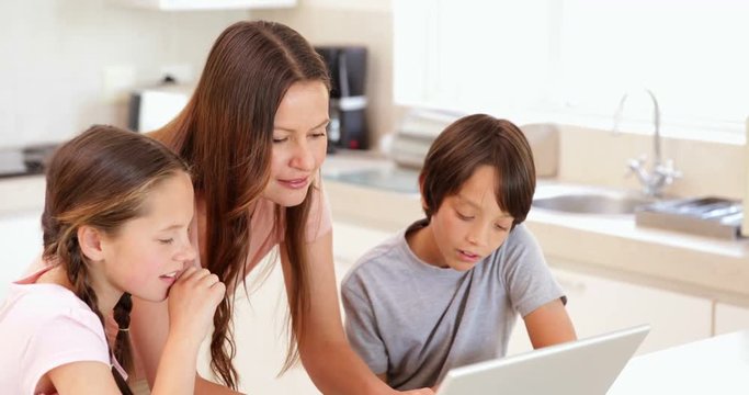 Mother using the laptop with her children