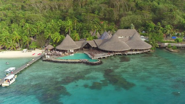 AERIAL: Luxury hotel resort with overwater villas and swimming pool