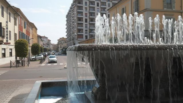 Mortara, Italy &ndash; circa May 2016: Cars passing by the station fountain, 
