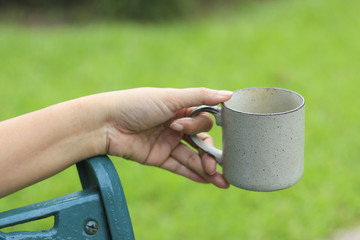 Stock Photo:.hand holding cup of coffee on natural morning backg