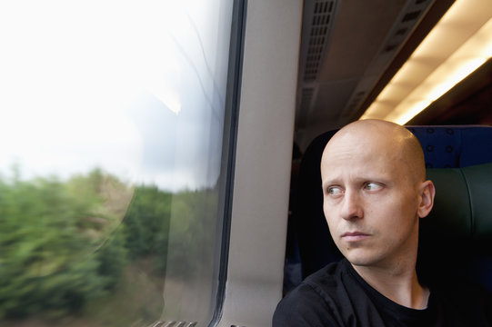 Man looking through window while traveling by train