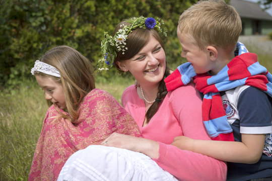 Sweden, Skane, Mother with children (6-7, 8-9) during midsummer celebrations