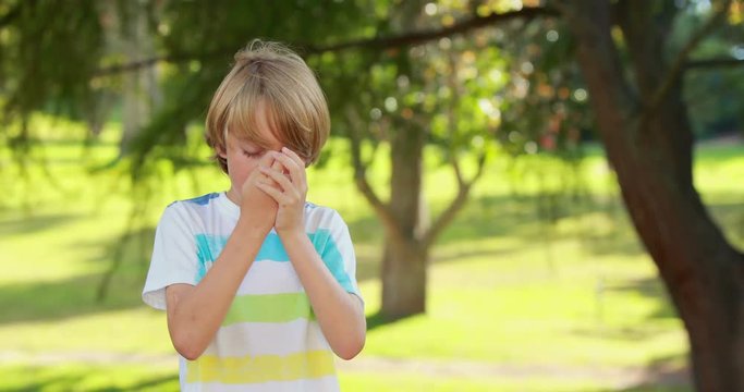 Little boy using his inhaler in the park