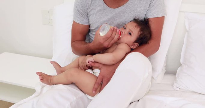 Handsome father feeding his baby