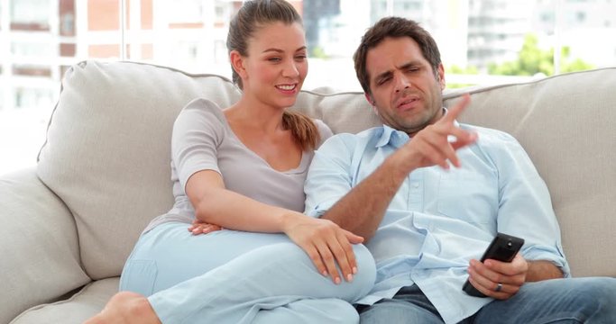 Relaxed couple watching tv on the couch