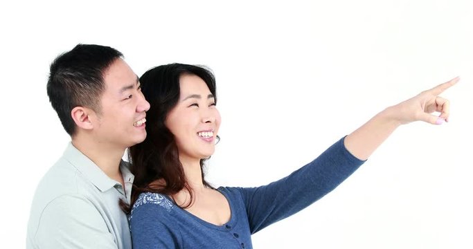 Happy couple pointing something on white screen