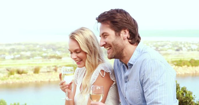 Cute couple laughing and drinking white wine