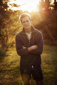 Sweden, Smaland, Loftahammar, Portrait of man standing with arms crossed at sunset