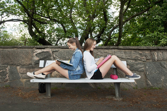Sweden, Vastra Gotaland, Gothenburg, Two girls (14-15) sitting on bench back to back
